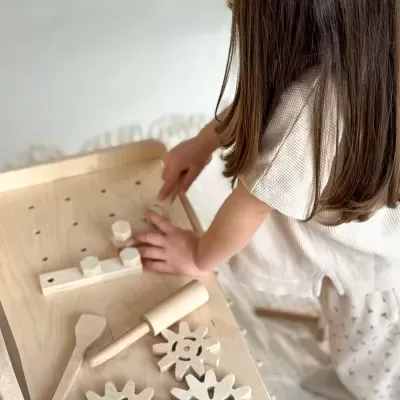 Jogo educativo de madeira natural com engrenagens e ferramentas, criança a brincar