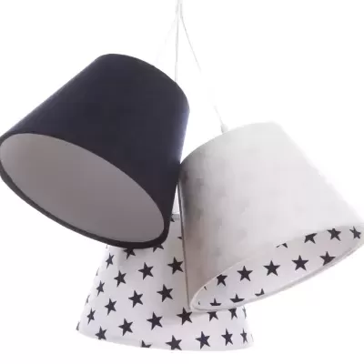 Candeeiro de tecto com três abajures, um preto, um branco e outro branco com estrelas pretas.