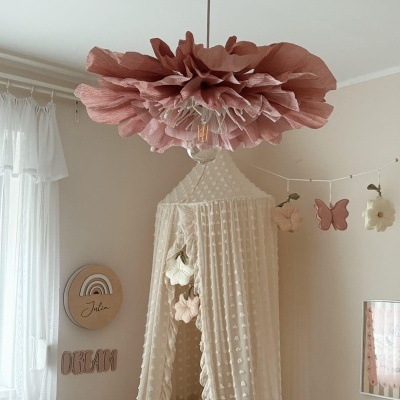 Lâmpada de teto floral cor-de-rosa em quarto com cortinado creme e decorações de parede em madeira