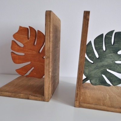 Dois suportes de livros em madeira com folhas de Monstera em laranja e verde