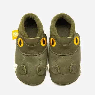 Sapatinhos infantis verdes com detalhes amarelos e etiqueta amarela.