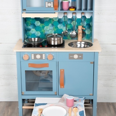 Cozinha infantil azul com utensílios e mini mesa com prato e talheres