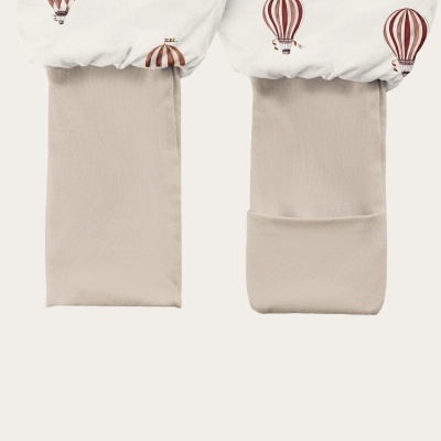 Leggings de criança com padrão de balões de ar quente castanhos em tecido branco e beje nas pernas, com meias destacáveis.