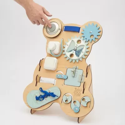 Painel de atividades infantil em madeira em forma de urso com peças azuis, trancas e cordas