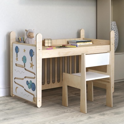 Mesa infantil de madeira com painel interativo, cadeira combinando, peluche e objetos sobre mesa