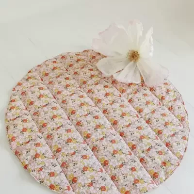 Tapete redondo acolchoado com padrão floral e flor branca decorativa