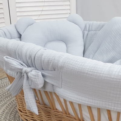 Berço portátil de verga com revestimento branco e laços decorativos