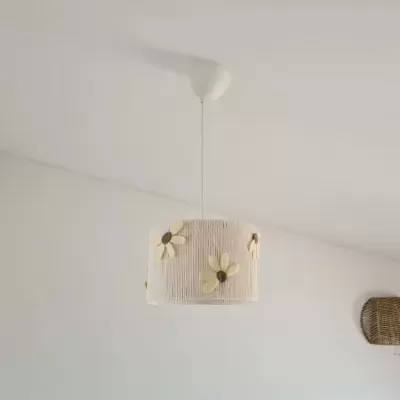 Candeeiro de teto branco com flores tridimensionais e cesto de vime na parede branca