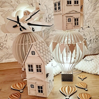 Lâmpadas decorativas com casas de madeira, avião em nuvem, balões de ar quente em madeira, piso de madeira clara, papel de parede com folhas e pássaros