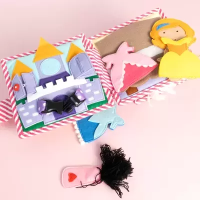 Livro de atividades infantil de tecido com castelo e figuras de feltro.