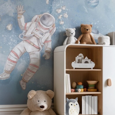 Estante infantil branca com brinquedos e peluches, parede azul com astronauta desenhado