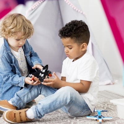 Duas crianças a brincar com blocos de construção num quarto infantil