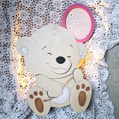 Painel em madeira de urso sorridente com raquete de pingue-pongue sobre manta de crochet branca