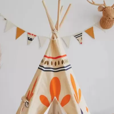 Tenda tipi de tecido decorada com padrões laranja e azul com bandeirolas coloridas e cabeça de veado na parede