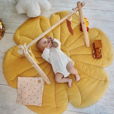 Tapete de atividade amarelo com estrutura de madeira e bebé a brincar