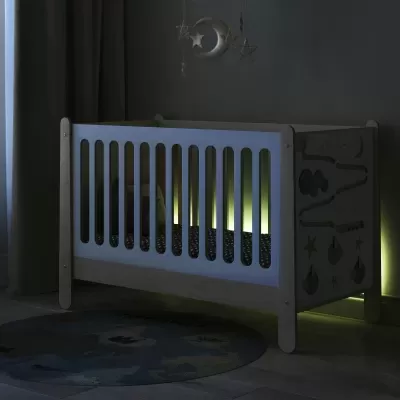 Berço de bebé em madeira clara com laterais brancas e painéis decorativos em quarto escuro