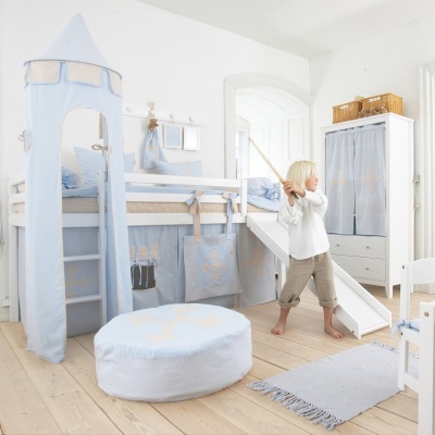 Quarto infantil com cama alta e escorrega decorado em azul e bege com tenda, pufe e armário
