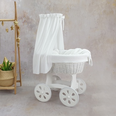 Carrinho de bebé branco em madeira e vime com tecido branco e tule ambiental