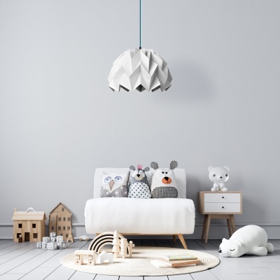Quarto infantil minimalista com sofá branco, almofadas de pelúcia, brinquedos de madeira e candeeiro branco geométrico