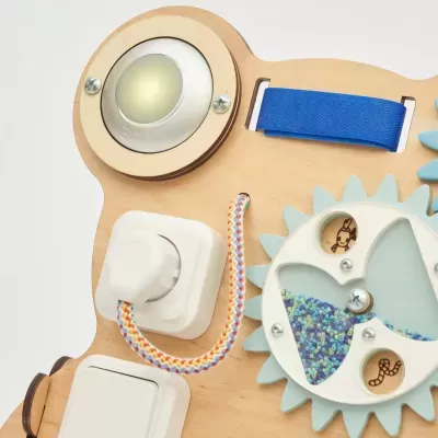 Painel sensorial com elementos de luz, cabo colorido e roda com sementes