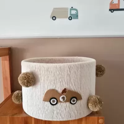 Cesto branco redondo com decoração de carro e pompons castanhos