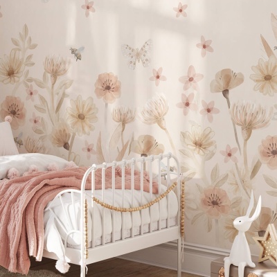 Berço branco de metal com manta rosa junto a parede floral pastel