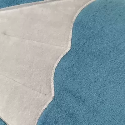 Tapete azul com tapete pequeno creme e bege em forma de concha