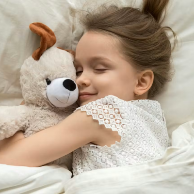 Criança deitada abraçando peluche de cão