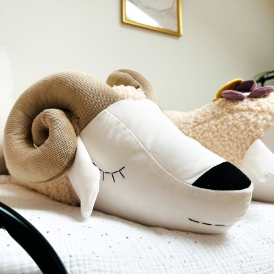 Almofada decorativa em forma de cabeça de carneiro com chifres castanhos claros e rosto branco