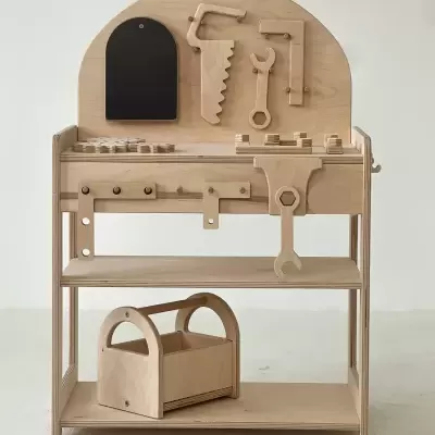 Bancada de trabalho infantil de madeira com ferramentas de madeira organizadas em fundo branco