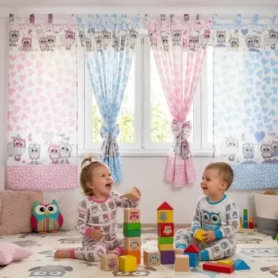 Cortinas rosa e azul com corujas em quarto infantil com crianças a brincar com blocos coloridos
