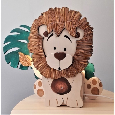 Abajur de madeira infantil em forma de leão com folhas decorativas verdes ao fundo