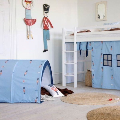Quarto infantil com cama alta branca e tenda azul decorada com soldados de chumbo