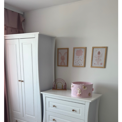 Quarto infantil com móveis brancos e decoração cor-de-rosa
