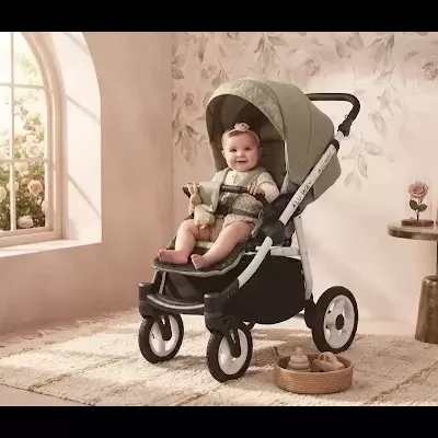 Carrinho de bebé verde com bebé sentado em ambiente decorado com parede floral e tapete bege