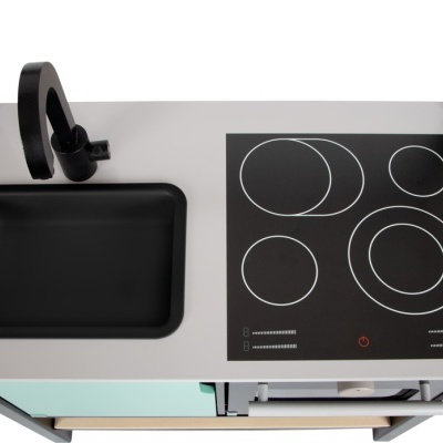 Cozinha infantil de madeira com lava-loiças preto e placa de fogão preta com círculos brancos