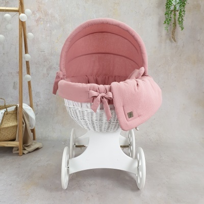 Carrinho de bebé branco em vime com tecido rosa