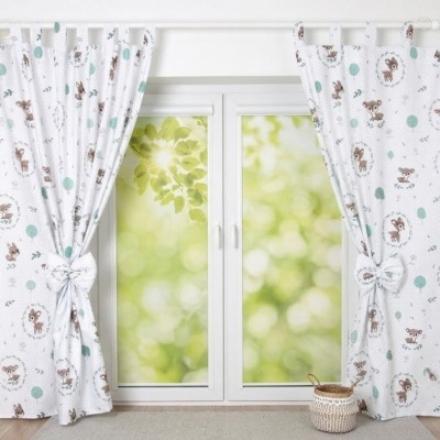 Cortinas brancas com padrão de animais e bolas verdes junto a porta de vidro dupla com vista verde desfocada