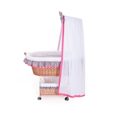 Berço de bebé em vime com tecido branco e floral, cobertura transparente branca com borda rosa