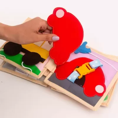 Livro infantil sensorial de tecido com figuras de veículos coloridos e fechos para encaixe