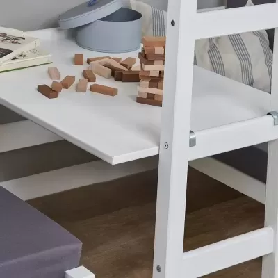 Mesa branca com bancos almofadados cinzentos e blocos de madeira de jogo sobre a mesa