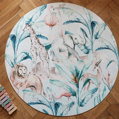 Tapete redondo com estampa de folhas e animais sobre chão de madeira
