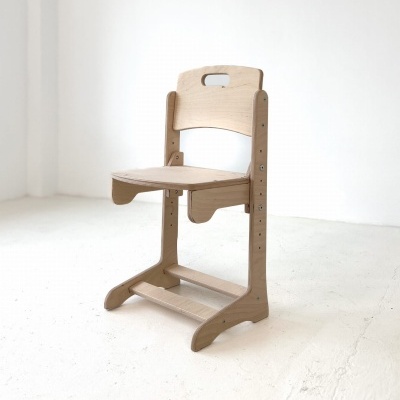 Cadeira infantil de madeira clara em ambiente minimalista branco