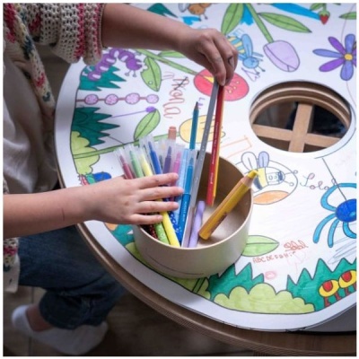 Mesa redonda para crianças com desenhos coloridos e material de desenho dentro de um compartimento circular