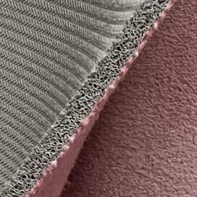 Superfície têxtil cinza e rosa com texturas distintas em detalhe