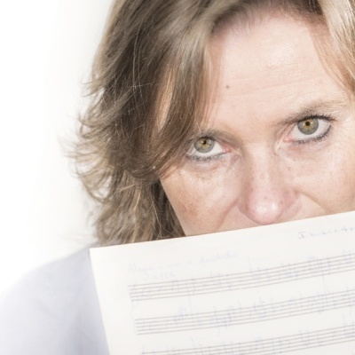 Mulher segurando folha de papel com pautas musicais
