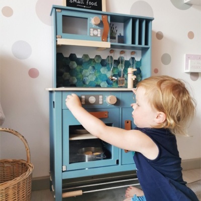 Cozinha infantil de madeira azul com acessórios e quadro negro com texto small foot small food