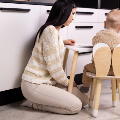 Cadeira infantil de madeira clara com banco branco numa cozinha moderna