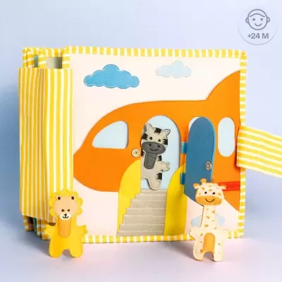 Livro de tecido com avião laranja e bonecos animais em peluche