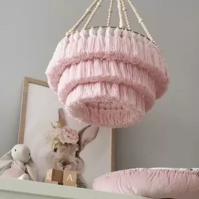 Candeeiro suspenso de franjas cor-de-rosa com decoração de coelho ao fundo